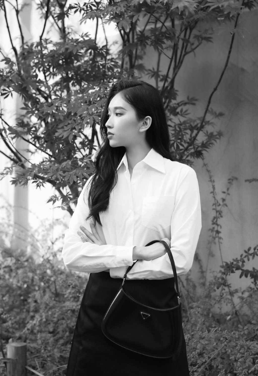 围墙下的一棵小树前，刘令姿白衫黑裙气质黑白写真美照