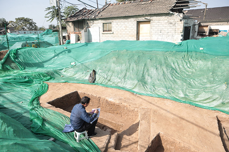 2019年10月20日，正在挖掘的古墓现场，考古工作人员正在对古墓信息进行记录。